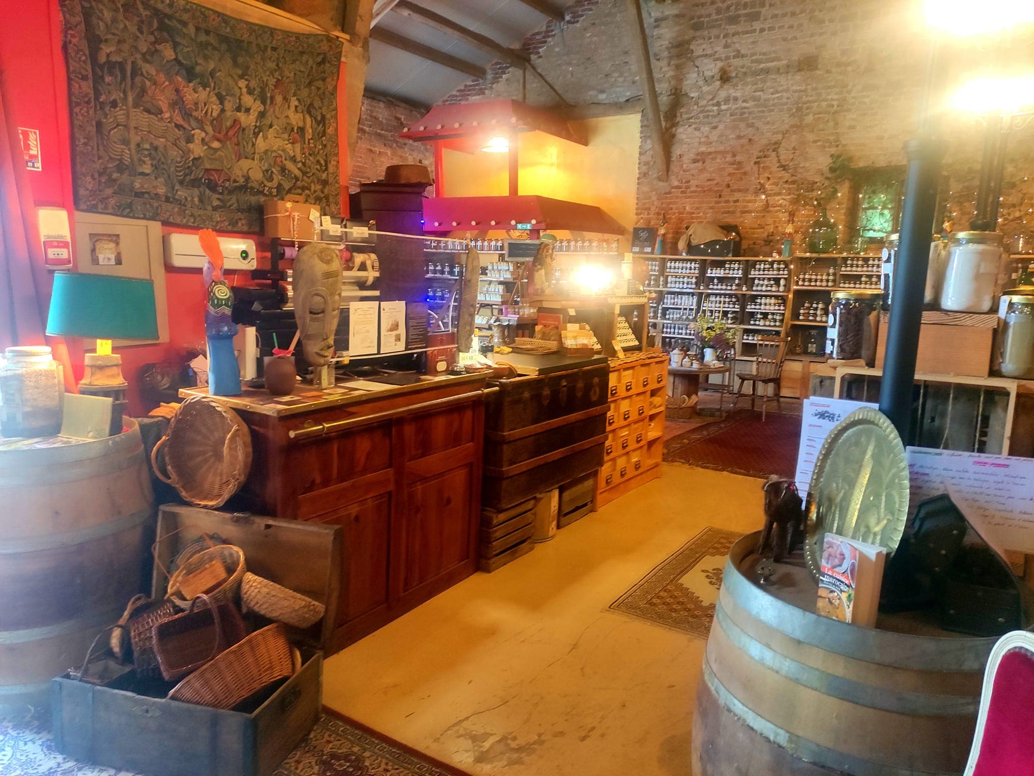 Intérieur chaleureux d'Épice & Compagnie - étagères en bois garnies de produits artisanaux d'exception
